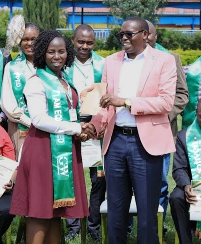 Optiven limited CEO George Wachiuri presenting a certificate to one of the graduates of a past cohort. Photo/Courtesy.